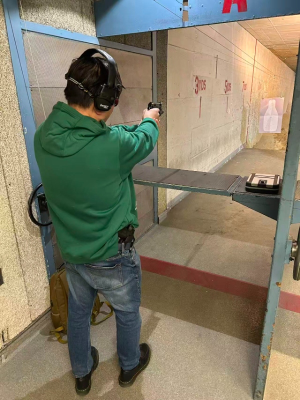 Student shooting pistol at range