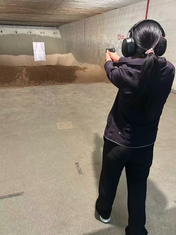 Student shooting pistol at indoor range